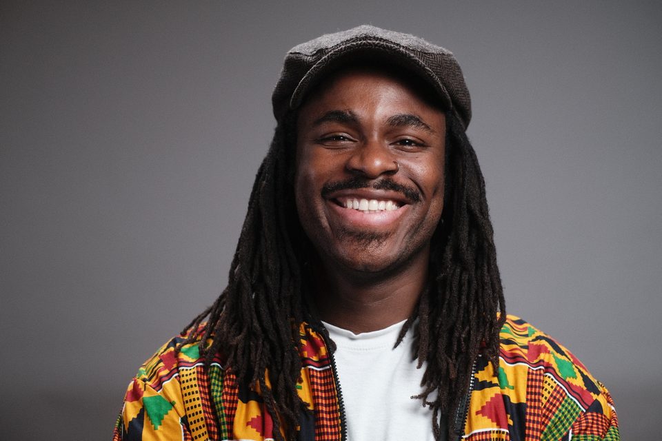 DJ Freegah souriant avec une veste à motifs et une casquette