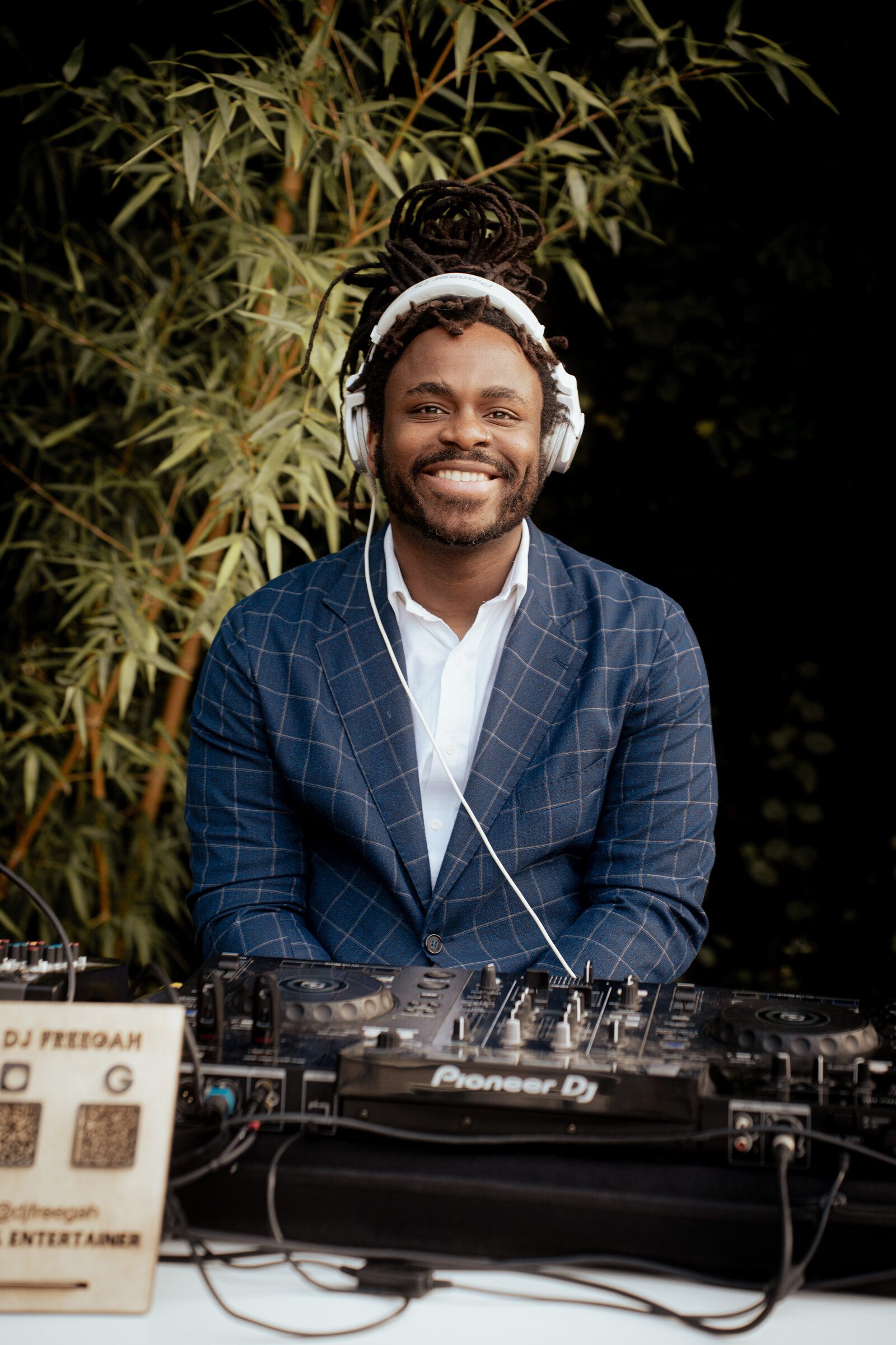 DJ Freegah souriant en costume derrière les platines